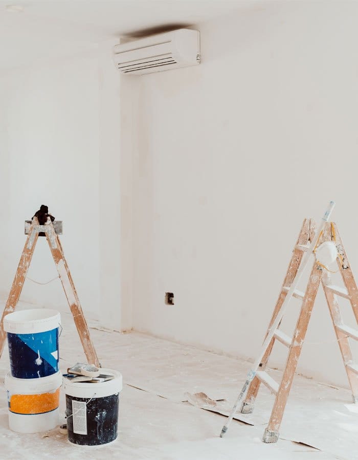 Interior painting prep with ladders and drop cloths